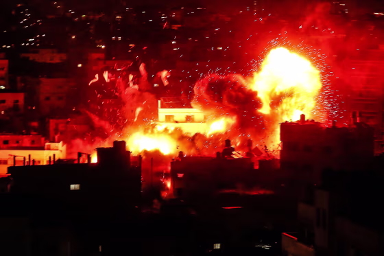 Image: A ball of fire above the building housing the Hamas-run television station al-Aqsa TV in the Gaza Strip