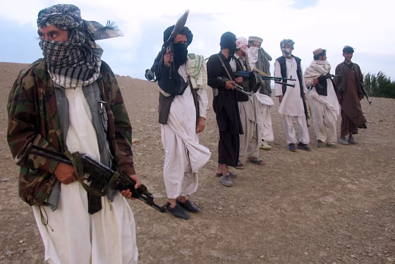 Image: Fighters with Afghanistan's Taliban militia standing on a hillside at Maydan Shahr in Wardak province, west of Kabul.