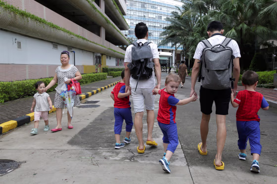 Image: An Hui, left, and his partner Ye Jianbin walk with their sons An Zhizhong, An Zhiya, and An Zhifei in Shenzhen, China, on Sept. 17, 2018.