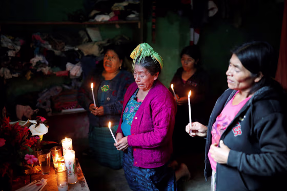 Felipe Gomez Alonzo's grandmother Catarina Perez , center, cries as she prays at an altar in her grandson's memory at the family's home in the village of Yalambojoch, Guatemala