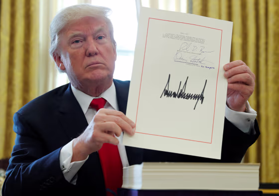 Image: President Trump displays signature after signing tax bill into law at the White House in Washington