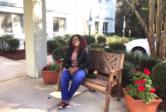 Photography of Shirley Henderson in front of her apartment building.