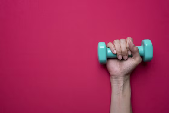 A woman holds a dumbbell