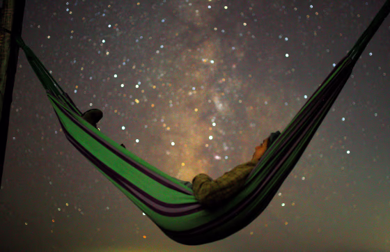 A girl lies in hammock as she looks at the milky way during the peak of Perseid meteor shower in Kozjak