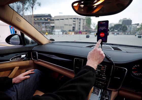 An engineer points to a Huawei Mate 10 Pro mobile used to control a driverless car during the Mobile World Congress in Barcelona