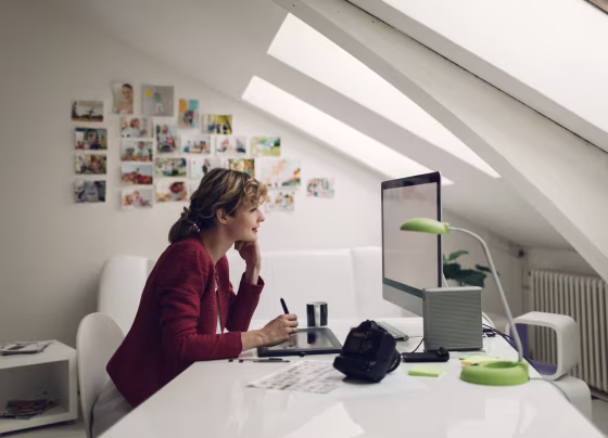 Image: Freelance female photographer sitting in her office and looking and editing images on her computer.