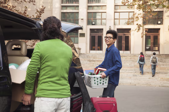 Young man moving into dormitory on college campus