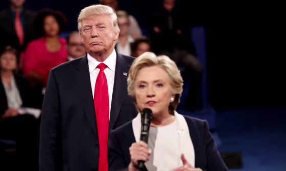 Image:Donald Trump listens as Hillary Clinton answers questions during a debate at Washington University in St. Louis, Missouri, on Oct. 9, 2016.