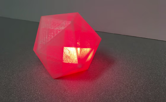 Image: A block-like geometric shape that emits a glowing red light when it hears swear words.