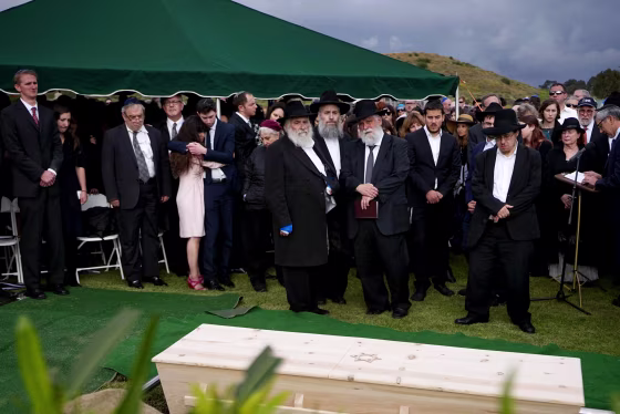 Image: Hannah Kaye, along with Jewish community leaders and mourners, stand near the coffin of her mother, Lori Kaye, at El Camino Cemetery in San Diego, California, on April 29, 2019. Lori Kaye was fatally shot at a synagogue in Poway.
