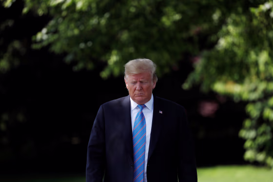 Image: President Trump walks towards reporters as he departs for travel to Louisiana from the White House in Washington