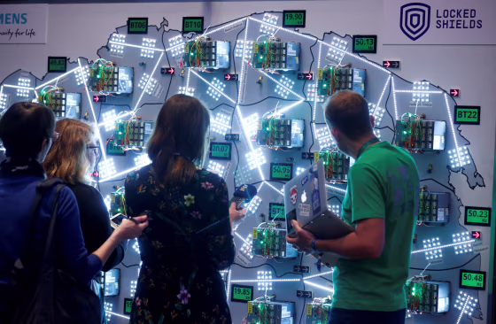 Image: People look at visualizations at a cyber defense exercise organize by NATO Cooperative Cyber Defence Centre of Excellence in Estonia on April 10, 2019.