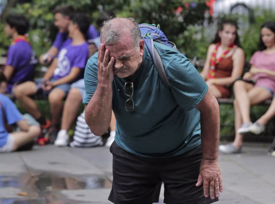 Russ Wilson splashes water on his face from a fountain in New York on July 17, 2019.