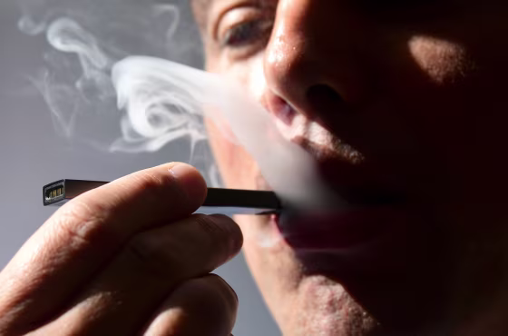 A man exhales smoke from an electronic cigarette.