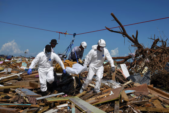 Image: Personnel from the Royal Bahamas Police Force and a U.S. urban search and rescue team remove a body from a destroyed neighbourhood in the wake of Hurricane Dorian in Marsh Harbour