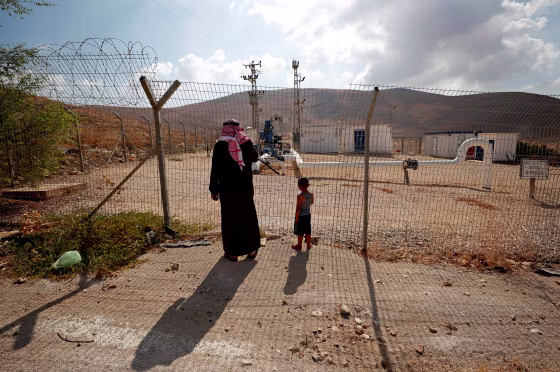 Image: Palestinians stand at a fence separating the Jordan Valley and the Israeli-occupied West Bank on Aug. 21, 2019.