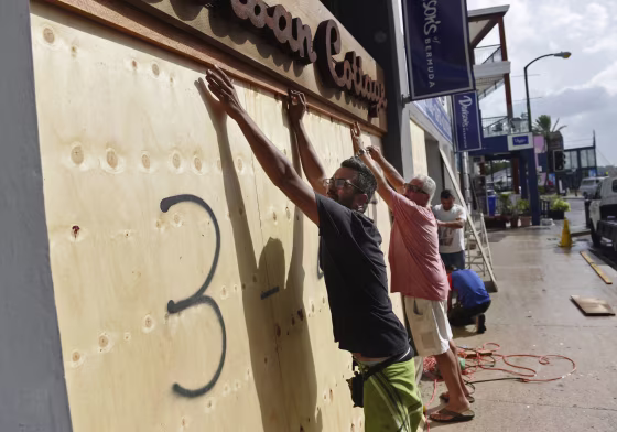 Image: People board up an Urban Cottage store in preparation for Hurricane Humberto in Hamilton, Bermuda