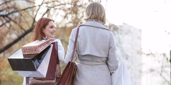 Women carrying shopping bags in city park