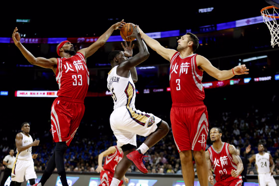 IMage: Houston Rockets' Corey Brewer, left, and Ryan Anderson attempt to block New Orleans Pelicans' player Lance Stephenson during an exhibition game in Shanghai in 2016.