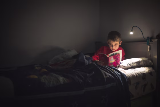 Image: Boy reading in bed