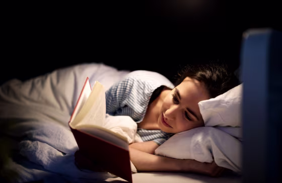 Woman reading book in bed