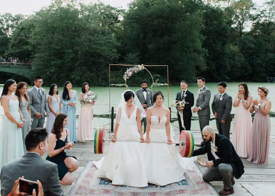Zeena Hernandez, left, and Lisa Yang, deadlift a 253 pound barbell during their wedding ceremony in Prospect Park