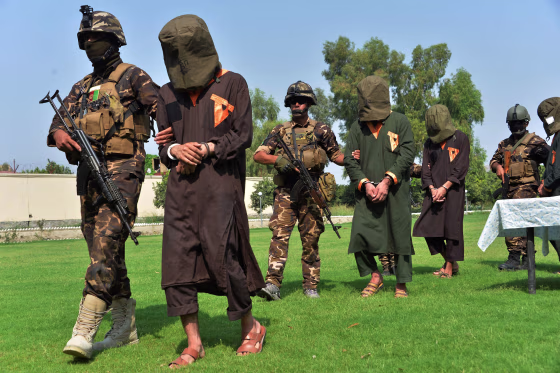 Image: Afghan security personnel escort arrested alleged Taliban and Islamic State militants during an operation in Jalalabad province