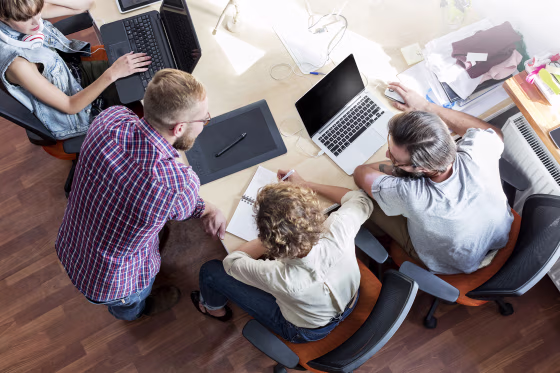 Image: People work at laptops during a meeting