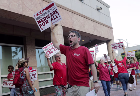 Supporters of medicare for all march outside a Democratic presidential debate in Miami