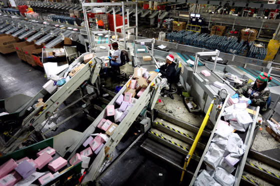 Image: U.S. Postal Service workers scan parcels at the Los Angeles Processing and Distribution Center on Dec. 11, 2019.