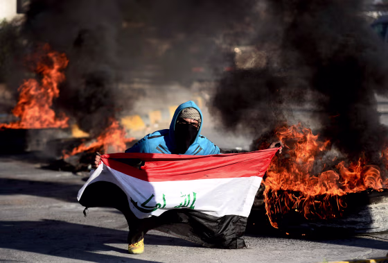 Image: An Iraqi demonstrator carries a flag during a protest over airstrikes that killed top Iranian and Iraqi military commanders in Najaf on Jan. 5, 2020.