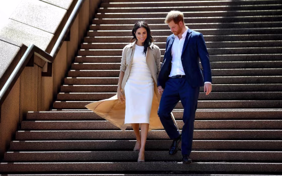 Image: Britain's Prince Harry and his wife Meghan walk down the stairs of the iconic Opera House to meet people on Oct. 16, 2018.