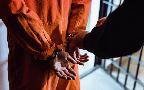 Image: Prisoner with handcuffs in cell