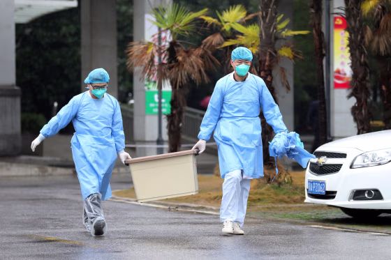 Image: Medical staff carry a box as they walk at the Jinyintan hospital, where the patients with pneumonia caused by the new strain of coronavirus are being treated, in Wuhan
