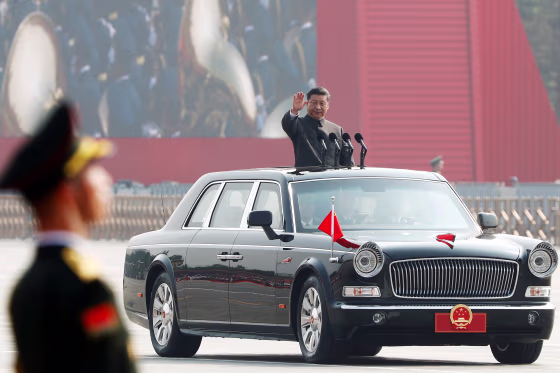 Image: Chinese President Xi Jinping waves from a vehicle as he reviews the troops at a military parade marking the 70th founding anniversary of People's Republic of China
