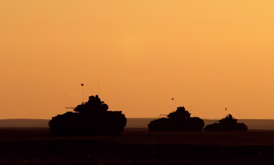 Image: U.S. Army Bradley Fighting Vehicles at sunset in Iraq in 2003.