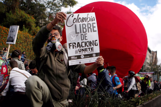 Image: An activist holds a sign that reads \"Colombia free of fracking\" during a climate change protest in Bogota, Colombia, on Sept. 8, 2018.