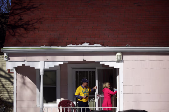 Image: Len Edgerly and Darlene Determan knock on a door while canvasing for Pete Buttigieg in Des Moines, Iowa, on Feb. 2, 2020.