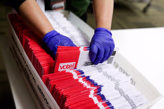 Image: A poll worker sorts vote-by-mail ballots in Renton, Wash., on March 10, 2020.