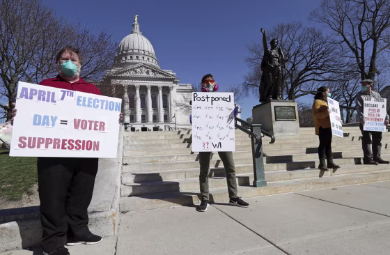 Image: A group with C.O.V.I.D., Citizens Outraged Voters in Danger, including, from left, Ron Rosenberry Chase and Jim O'Donnell, protest while wearing masks outside the State Capitol during a special session regarding the spring election in Madison, Wis