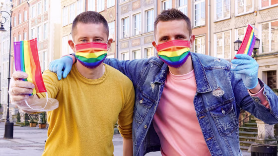 Image: Gay couple Dawid Mycek and Jakub Kwiecinski pose with the rainbow-patterned face masks on a street in Gdansk