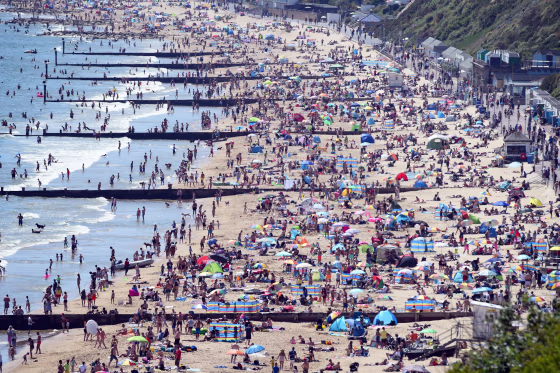 Image: Tourists enjoy the hot weather at the beach in Bournemouth
