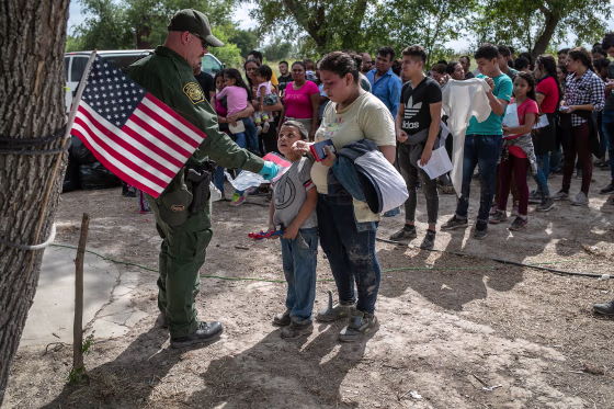 Image: A U.S. Border Patrol agent gathers personal effects from immigrants before they were transferred to a McAllen processing center on in Los Ebanos, Texas.