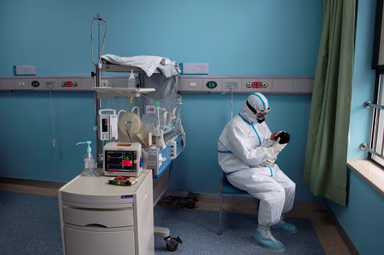 Image: Nurse in protective suit attends to a baby with COVID-19, caused by the coronavirus, at an isolation ward of Wuhan Children's Hospital in Wuhan