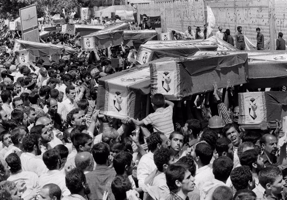 Mourners carry coffins through the streets of Tehran, Iran, during a mass funeral for the victims aboard Iran Air flight 655, which was shot down by the USS Vincennes in the Persian Gulf, on July 3, 1988.