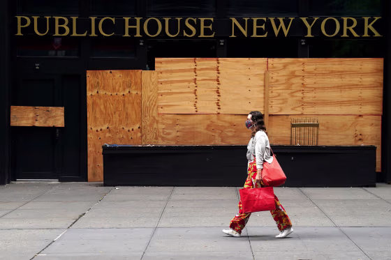 Image: A woman walks past a shuttered bar following the coronavirus (COVID-19) disease outbreak