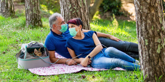 Couple on picnic wearing face masks with their cat. Shop picnic essentials for a day in the park, backyard or roof, including a picnic basket, face mask, hand sanitizer, sunscreen and more.