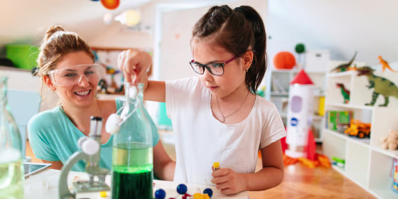 Mother and young daughter doing science experiment at home