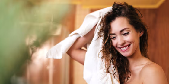 woman drying hair with towel