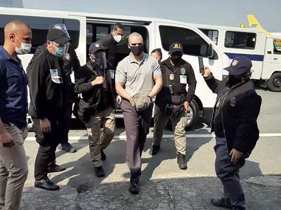 Image: U.S. marine Lance Corporal Joseph Scott Pemberton (C), who was convicted of killing a transgender woman and recently pardoned by Philippine President Rodrigo Duterte, escorted by immigration officers and US personnel as he arrives at the airport in